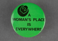 A lime green badge with black text that says a womans place is everywhere. There is also a silhouette of a rose printed in black.