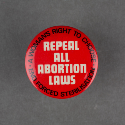 A bright red badge with white text that says Repeal All Abortion Laws in capitals.