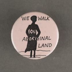 A light pink badge with the silhouette of a woman and the words we walk on aboriginal land over laid.
