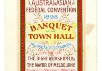 A cream and red invidiation DL sized. There is a red cross at the top and in the centre red block text that reads Banquet Town Hall.
