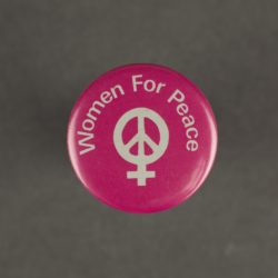 Hot pink badge with a while peace sign displayed in the centre. The words 'women for peach' in displayed arched over the top of the peace sign.